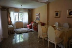 a living room with a table and chairs and a couch at Villa Valdelagrana fantástica para familias in Cádiz