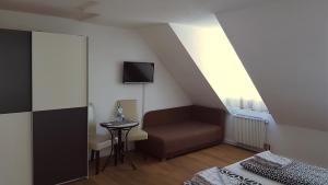 Habitación con cama, silla y TV. en Gut Lauterbad Hotel en Freudenstadt