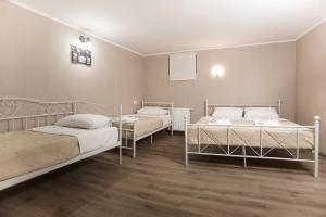 two beds in a room with wooden floors at Home25 in Tbilisi City