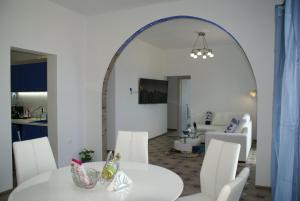 ein Esszimmer mit einem weißen Tisch und weißen Stühlen in der Unterkunft Island Apartment in Kavala