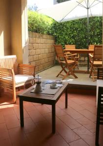 a patio with a table and chairs and an umbrella at Appartamenti Boboli in Punta Ala