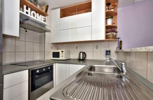 a kitchen with a sink and a microwave at Apartment Mirjana in Makarska