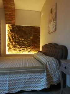 a bedroom with a bed and a stone wall at Montorfano Suite in Rovato