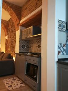 a kitchen with an oven and a living room at Montorfano Suite in Rovato