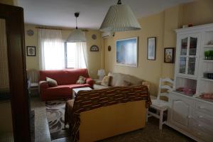 a living room with a couch and a red chair at Villa Valdelagrana fantástica para familias in Cádiz +60 photos