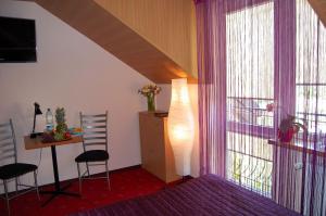 salon ze stołem i krzesłami oraz oknem w obiekcie Villa Orchidea w Grzybowie