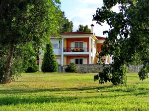 a house with a green yard with trees at Villa Giannopoulos in Áyios Ioánnis