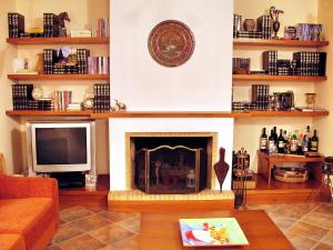 a living room with a fireplace and a tv at Villa Giannopoulos in Áyios Ioánnis