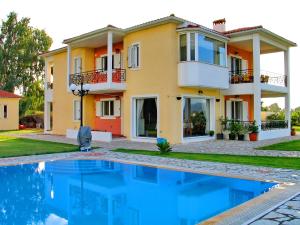 a house with a swimming pool in front of a house at Villa Giannopoulos in Áyios Ioánnis