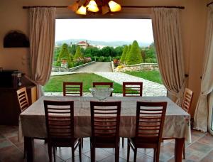 a dining room with a table and chairs and a large window at Villa Giannopoulos in Áyios Ioánnis