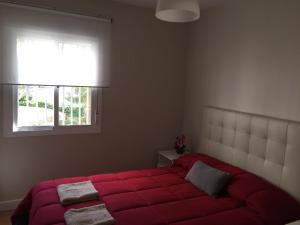 ヘレス・デ・ラ・フロンテーラにあるApartamento Jerez Holidaysのベッドルーム1室(赤い大型ベッド1台、窓付)
