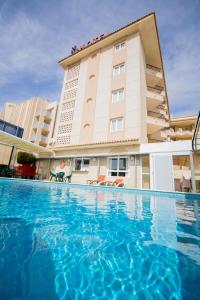een hotel met een zwembad voor een gebouw bij Hotel Guardamar in Guardamar del Segura