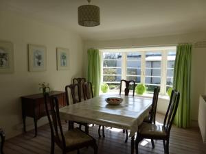 a dining room with a table and chairs and a window at Shore Cottage in Dumfries