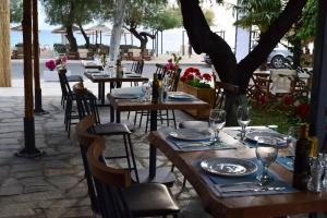 a group of tables with plates and wine glasses on them at Astri Hotel in Neos Marmaras