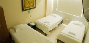 a hospital room with two beds and a mirror at Rivera del Rio Hotel in Piura