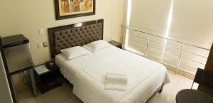 1 dormitorio con 1 cama blanca en una habitación en Rivera del Rio Hotel, en Piura