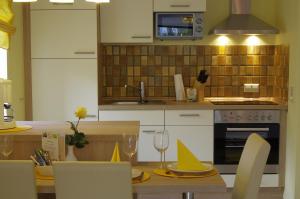 una cocina con una mesa con platos y copas de vino en Haus Roseneck mit THERMEplus, en Bad Bevensen