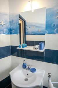 a bathroom with a white sink and a mirror at La casa del pescatore in Oliveri