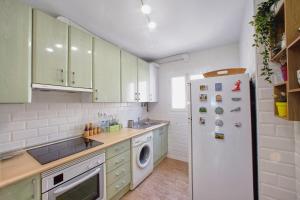 kuchnia z zielonymi szafkami i białą lodówką w obiekcie Casa Volare- estilo y relax en pleno casco antiguo w Maladze +37 zdjęć