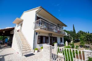 ein weißes Haus mit einer Treppe und einem Balkon in der Unterkunft Apartmani blagaic in Maslinica
