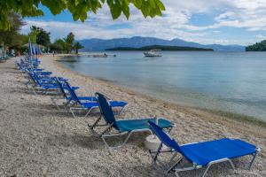 a row of blue chairs on a beach at The Beach House in Nydri