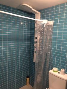 W wyłożonej niebieskimi kafelkami łazience znajduje się prysznic i toaleta. w obiekcie Canary Islands getaway w mieście Caleta De Fuste