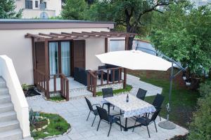 a patio with a table and chairs and an umbrella at KUĆA ZA ODMOR NATALIJA in Pula