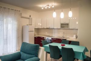 a kitchen with a table and chairs and a kitchen with white cabinets at KUĆA ZA ODMOR NATALIJA in Pula