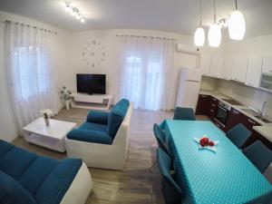 a kitchen and living room with blue chairs and a table at KUĆA ZA ODMOR NATALIJA in Pula