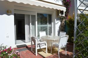 un patio con mesa y sillas en un porche en White Pearl Beach - Elviria Playa en Marbella