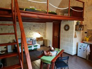 a room with a bunk bed with a table and a kitchen at Guesthouse A Casina b&b in Trani