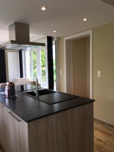 a kitchen with a black counter top and a sink at Maison du golf in Nieuwpoort