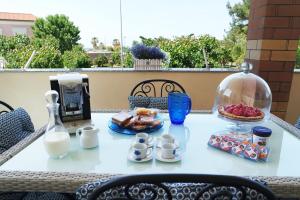 stół z jedzeniem i szklana miska mleka w obiekcie Eleatica Holiday Apartment w mieście Ascea