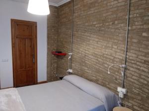 バレンシアにあるApartamento con estiloのレンガの壁、ベッド付きのベッドルーム1室