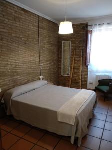 バレンシアにあるApartamento con estiloのレンガの壁のベッドルーム1室(大型ベッド1台付)