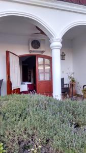 a red door on a white house with a porch at Hotel Portal del Santo in Cafayate