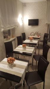 une salle à manger avec des tables, des chaises et une télévision dans l'établissement Gemini Suite, à Rome