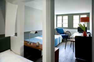 a bedroom with a bed and a desk with a desk at Appartements Au-Dessus Du... in Strasbourg