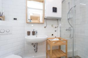 a white bathroom with a sink and a shower at Apartment Piccolo in Baška