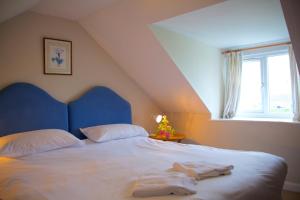 a bedroom with a bed with two towels on it at Powillimount Cottage in Kirkbean