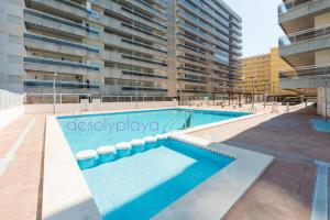 a swimming pool in front of a building at desolyplaya Colomeras 2J in Oropesa del Mar