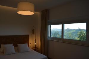 a bedroom with a bed and a large window at Maison Margot in Acquaviva Picena