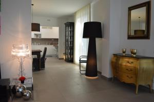 a living room with a floor lamp and a dresser at Maison Margot in Acquaviva Picena