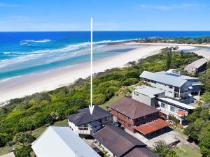 an aerial view of a house and a beach at White Waves on the Beach in Hastings Point