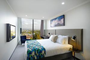 Una habitación de hotel con una cama y una ventana grande. en Mantra Albury, en Albury