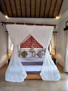 a bedroom with a bed with mosquito nets at Ubud Lestari Bungalows in Ubud