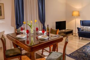 comedor con mesa con sillas y sofá en Daplace - Augusta Apartment, en Roma
