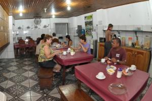 a group of people sitting at tables in a restaurant at Hotel Granada Concept in Manaus