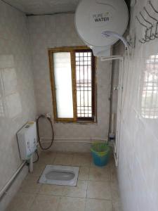 a bathroom with a toilet and a window in it at Xiasi Ancient Town Yang Gou Guesthouse in Xiasi