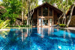 a swimming pool in front of a house at The Tubkaak Krabi Boutique Resort - SHA Extra Plus in Tab Kaek Beach